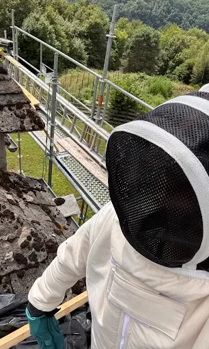 Technicien en combinaison de protection sur un échafaudage de toiture